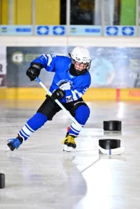 Spieler im blauen Trikot läuft mit Tempo durch einen Puck-Parcours