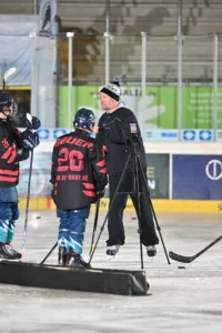 Trainer filmt die Spieler auf dem Eis für die Videoanalyse
